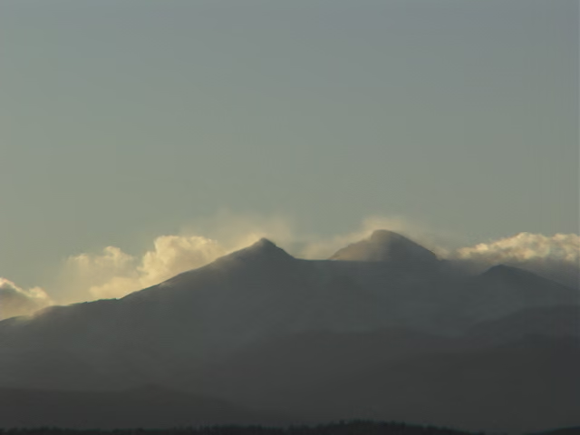 Mountains in the distance covered in clouds under a clear sky